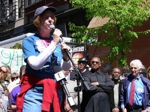 Cindy Sheehan speaking during the march opposing the War in Iraq (Jesse Jackson and Daniel Ellsberg in the background at right)