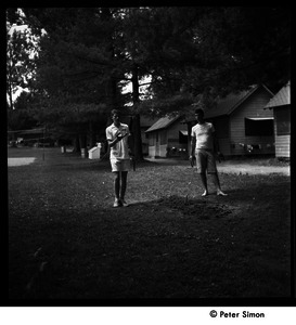 Camp Arcadia: campers playing horseshoes in front of the cabins