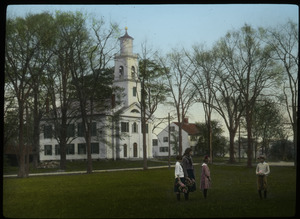 Children in grass in front of meeting house/ church