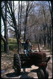 Harvey Wasserman riding a tractor down the road, Montague Farm Commune