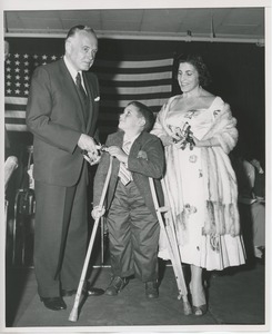 Young boy on crutches receiving diploma at Institution Day