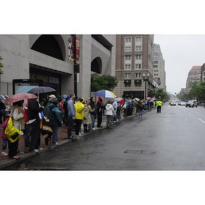 A crowd outside Copley Square waits for "One Run" runners in the rain