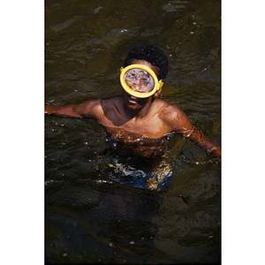 Child wearing snorkel mask in the water