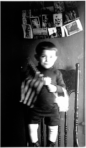 A little boy holding an American flag in the Back Central Street neighborhood.