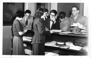 Suffolk University students crowd around a desk to register for class