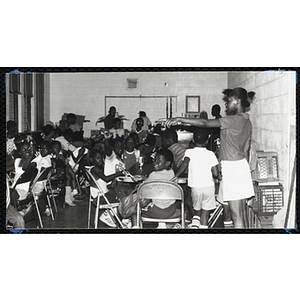 Jerry Steimel, Charlestown Boys & Girls Club director, looking up at the camera while standing with the Club members and guests during an event