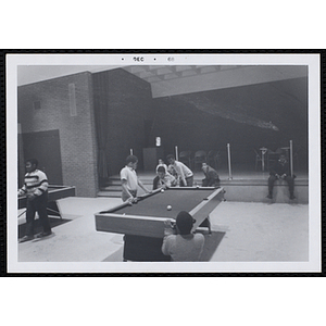 A Group of boys playing pool in the game room