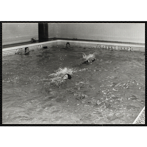 A boy swims the backstroke in a natorim pool