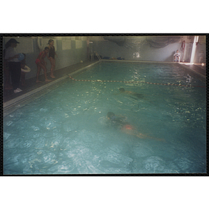 Two children swim in a natorim pool