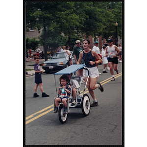 A woman runs as she pushes a stroller during the Battle of Bunker Hill Road Race