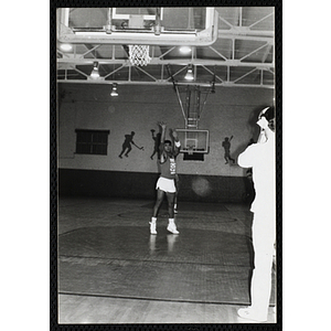 A teenage boy shoots a basketball