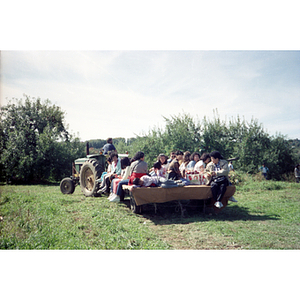 People riding on a wagon during a Chinese Progressive Association trip