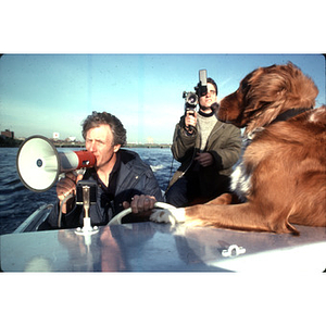 Crew coach Buzz Congram using a megaphone while steering a boat