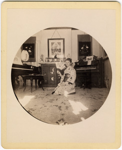Abby F. Blanchard kneeling in the parlor, with fan and kimono