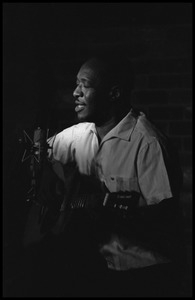 Josh White performing on guitar in a coffeehouse