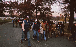 Women wearing masks walk with demonstrators