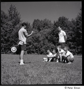 Camp Arcadia: counselor instructing young campers in archery