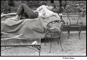 Peter Simon and Karen Helberg lying on a covered outdoor couch