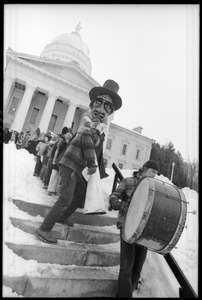 Bread and Puppet Theater descending the steps at the Vermont State House, follow a man with a bass drum, during a demonstration against the invasion of Laos