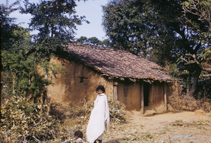 Young Munda woman and child near house