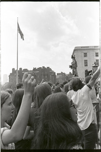 Demonstration at State House against the killings at Kent State: protesters raising their fists and gathering around American flag