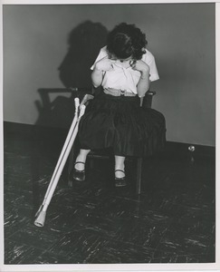 Unidentified woman with cerebral palsy looking down at her shirt