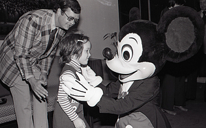 Man and child with Disney character Mickey Mouse