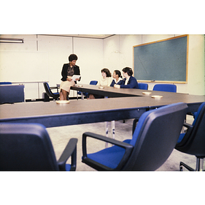 Four women speaking at a classroom desk