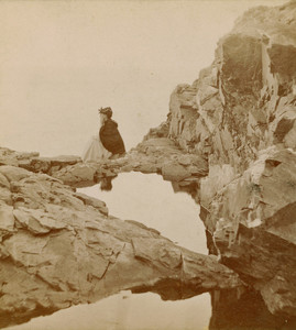 Stereograph of a woman seated on a rock, Crystal Pool, Bar Harbor, Maine, undated