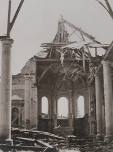 Interior view of a destroyed church with a crucifix hanging from the ruins, along the road from Verdun to Dun-sur-Meuse