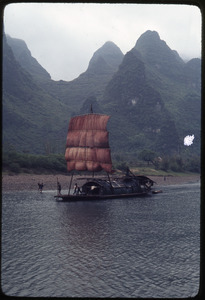 Red sailed paddle boat