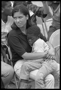 White woman in the Solidarity Day crowd at the Poor People's March on Washington, hugging an African American child while Coretta Scott King speaks