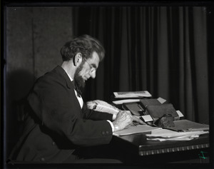 Lincoln Caswell, Abraham Lincoln impersonator, seated at a desk, writing