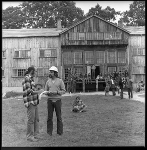 Man in a hard hat talking with commune member outside the Brotherhood of the Spirit dormitory in Warwick, Mass.