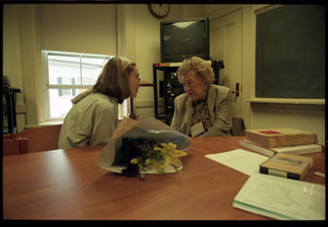 Julia Child, seated at a table, talking with a student