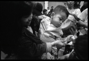Cambodian New Year's celebration: mother and infant giving money to musicians