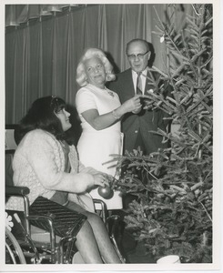 Margaret Milbank Bogert and Dr. DiMichael decorating Christmas tree with client in wheelchair