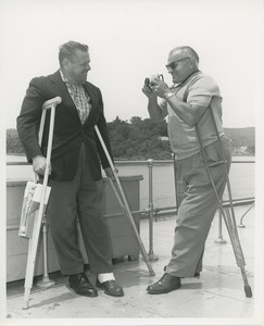 Man with crutches takes picture of man with crutches