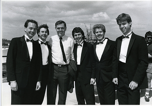 Mayor Raymond L. Flynn standing by waterfront with five unidentified men in tuxedos