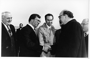 Boston City Councilor Thomas Menino shaking hands with an unidentified man as others watch on