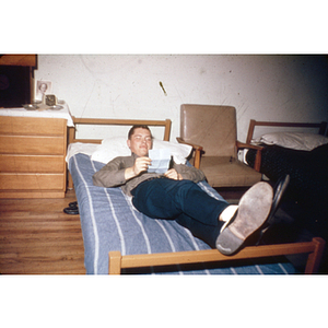 Student reading on bed in dorm