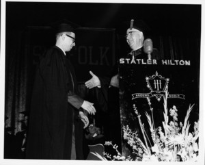 Suffolk University President Robert J. Munce (1955-1960) shakes the hands of a graduate at the 1960 Suffolk University commencement