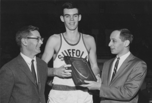 Suffolk University basketball player Jay Crowley receives an award from Ronald Weinberg and Charles Law