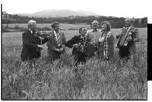 McElroy family, group of 14 traditional musicians. Pictured in a barley field