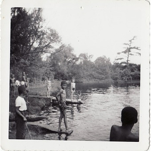 A group of boys stand at the edge of a manmade lake at Breezy Meadows Camp