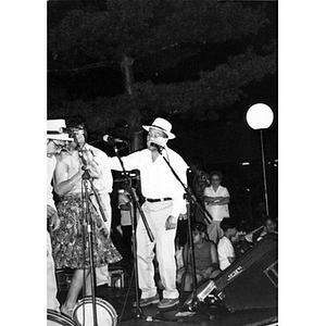 Singers on Festival Betances' outdoor stage performing at night.