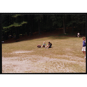 Two girls sitting together in a field during a Boys and Girls Club event