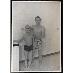A boy and man pose for a candid shot in a pool shower