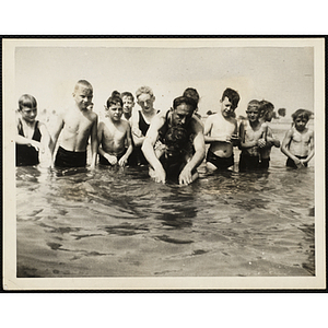 A man conducts swimming lessons for a group of boys at Carson Beach