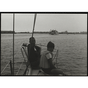 Two boys looking back from where they are sitting in a boat